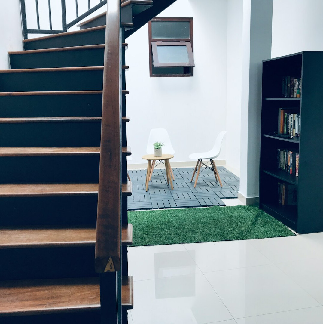 Bright modern office reception area with plants and a wooden desk