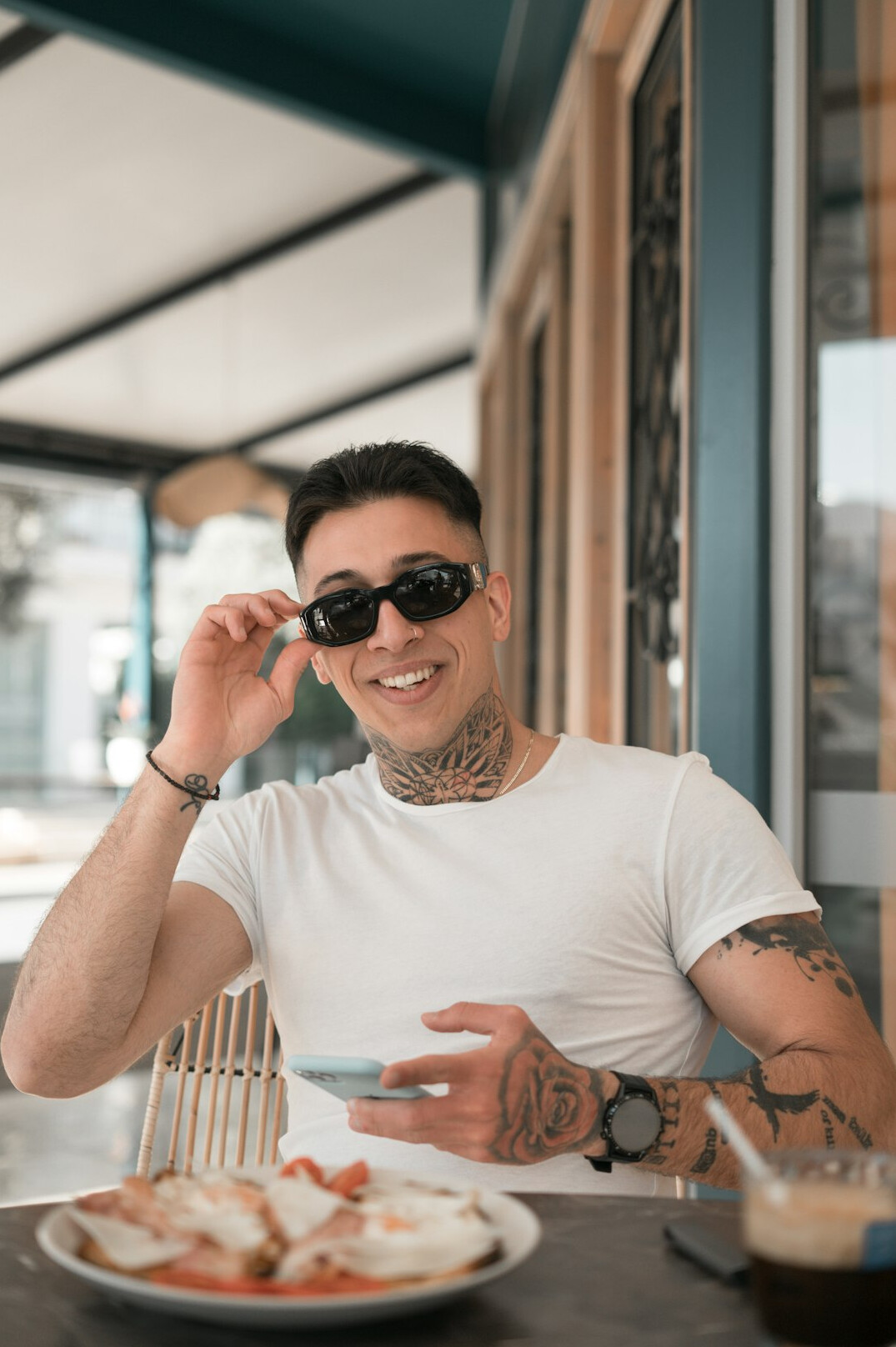 Portrait of a man with glasses smiling in a cafe
